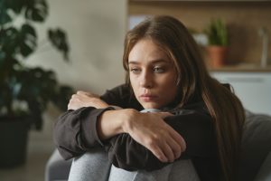 how to overcome depression-woman hugging knees looking glum