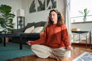 young woman meditating with headphones on